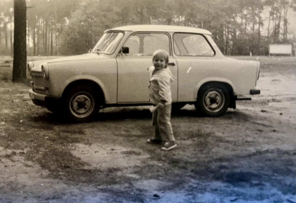 Christoffer Brick als Kind neben einem Trabant in der DDR